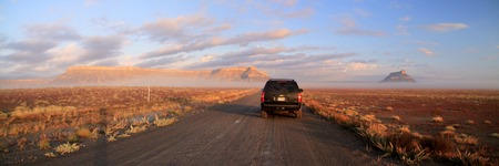 Petit matin brumeux sur une piste à l'est du parc national de Capitol Reef, avec Factory Butte dans le lointain